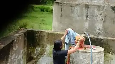 Indian village girl bathing near water tank outdoor
